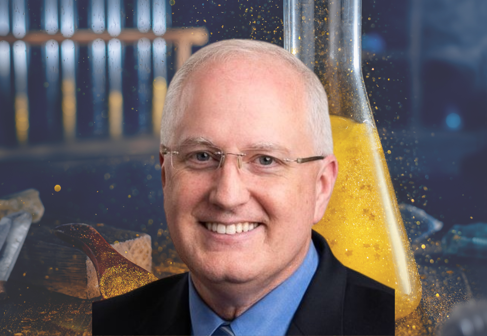 Smiling man with glasses and short gray hair in a suit, in front of a blurred background featuring laboratory equipment, including test tubes and a large flask filled with yellow liquid. EFESO Management Consultants