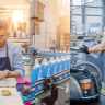 A collage shows a man labeling bottles, blue bottles on an assembly line, and a worker driving a floor cleaning machine in an industrial setting. EFESO Management Consultants